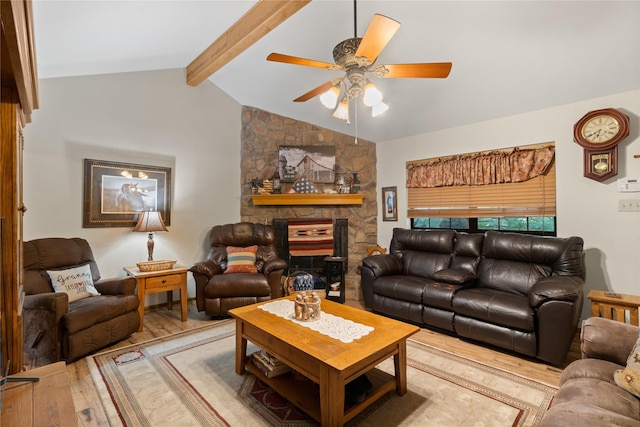 living room featuring hardwood / wood-style flooring, ceiling fan, a stone fireplace, and vaulted ceiling with beams