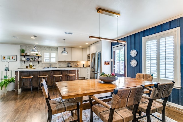 dining area featuring a healthy amount of sunlight, sink, and dark wood-type flooring