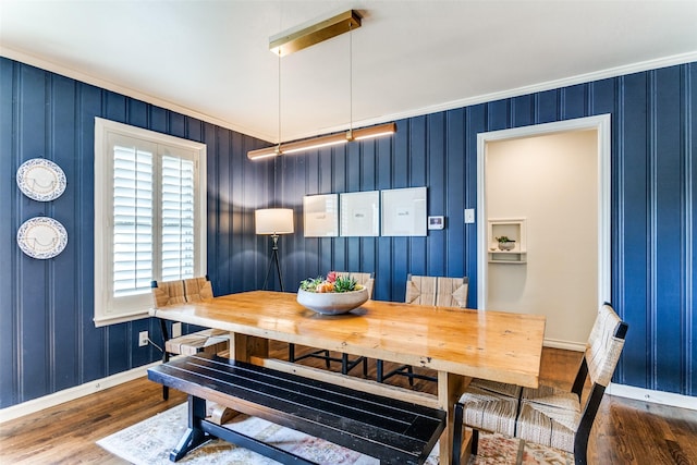 dining area with dark hardwood / wood-style flooring and ornamental molding