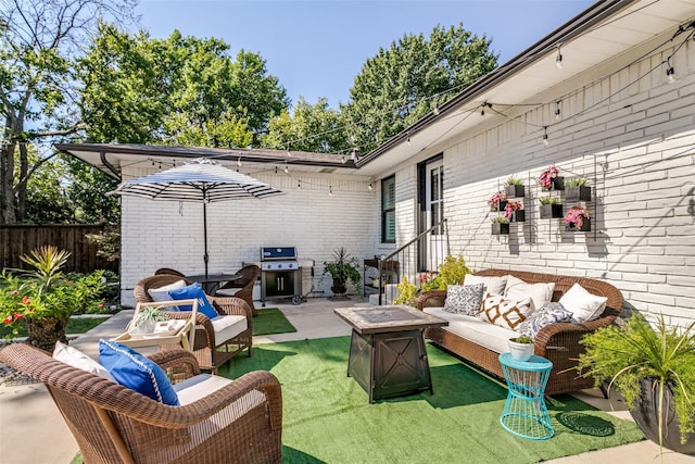 view of patio with area for grilling and an outdoor living space with a fire pit