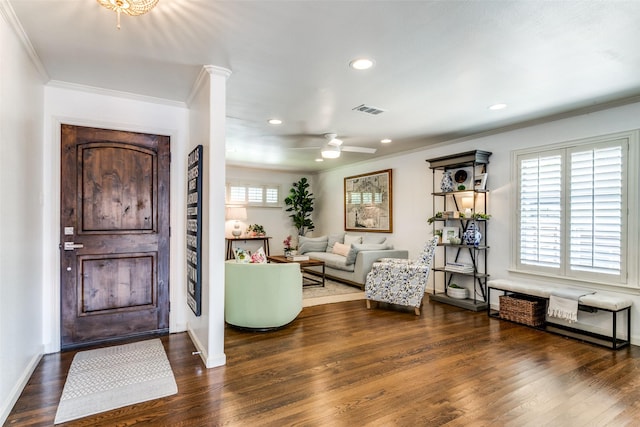 foyer entrance with decorative columns, ceiling fan, dark hardwood / wood-style floors, and ornamental molding