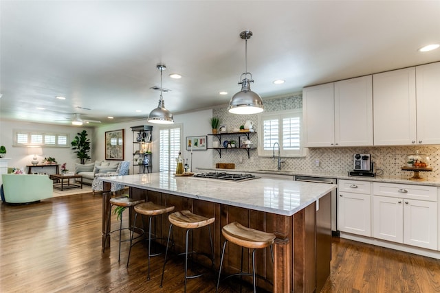 kitchen with ceiling fan, white cabinets, and a kitchen island