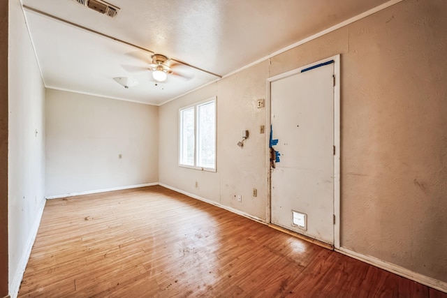 foyer entrance with ceiling fan, crown molding, and wood-type flooring