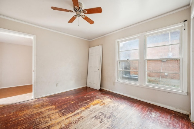 unfurnished room with crown molding, ceiling fan, and dark wood-type flooring