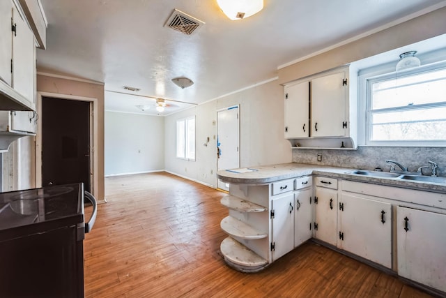 kitchen featuring kitchen peninsula, white cabinetry, ceiling fan, and sink