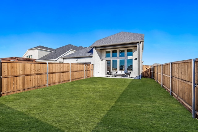 rear view of house featuring a yard and a patio