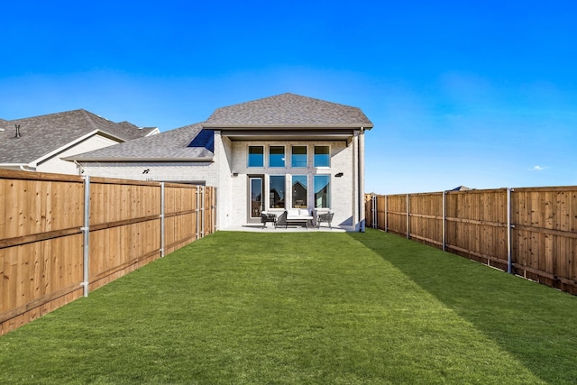 rear view of property featuring a lawn and a patio