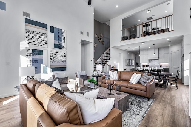 living room featuring light hardwood / wood-style floors and a high ceiling