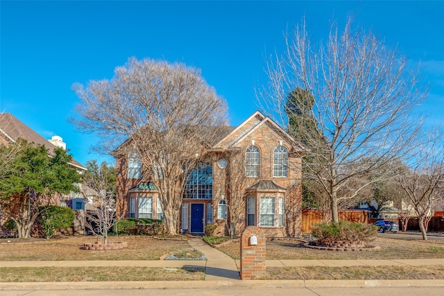 traditional home with brick siding and fence