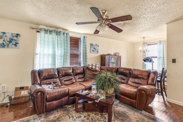 living room with ceiling fan with notable chandelier, hardwood / wood-style floors, and a textured ceiling