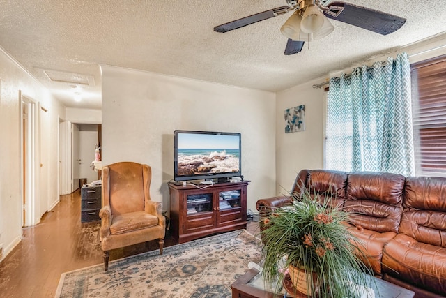 living room featuring ceiling fan, a textured ceiling, and light wood-type flooring