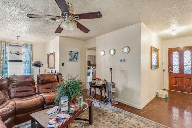 living room featuring ceiling fan with notable chandelier and a textured ceiling