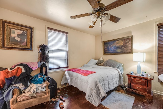 bedroom featuring multiple windows, dark hardwood / wood-style floors, and ceiling fan