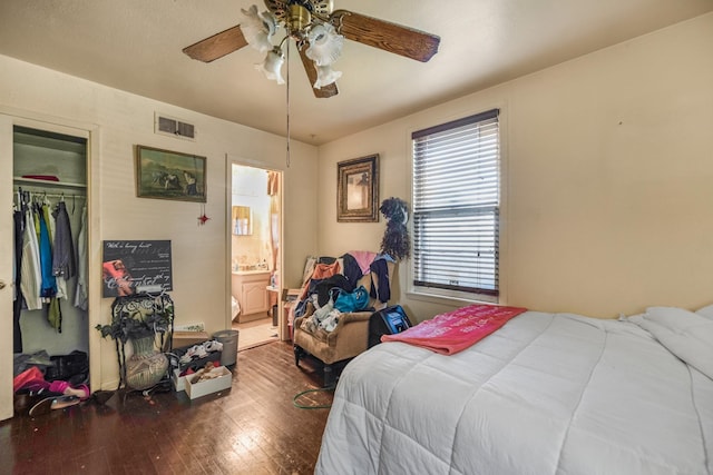 bedroom featuring hardwood / wood-style flooring, ensuite bath, a closet, and ceiling fan