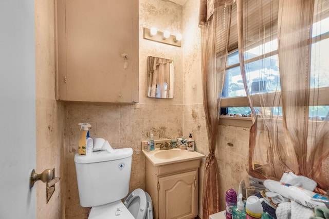 bathroom with tile walls, vanity, and toilet