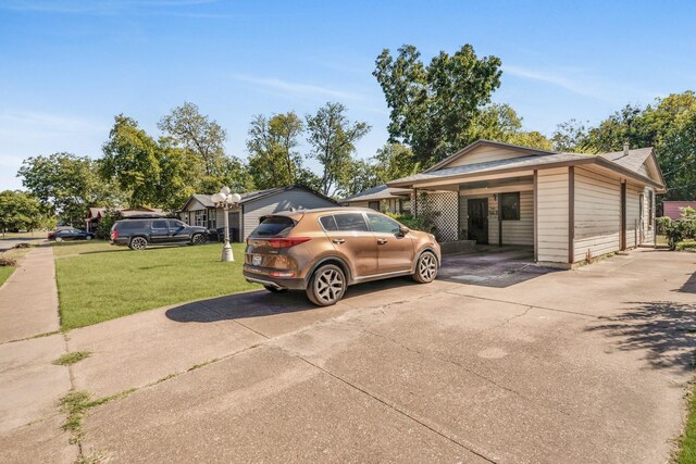 view of side of home with a carport and a lawn