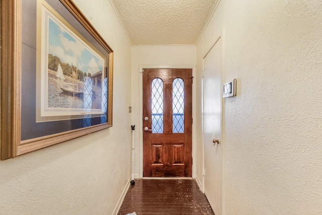 doorway featuring dark hardwood / wood-style floors, ornamental molding, and a textured ceiling