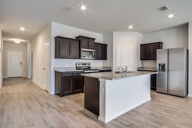 kitchen featuring sink, a center island with sink, light hardwood / wood-style flooring, and appliances with stainless steel finishes