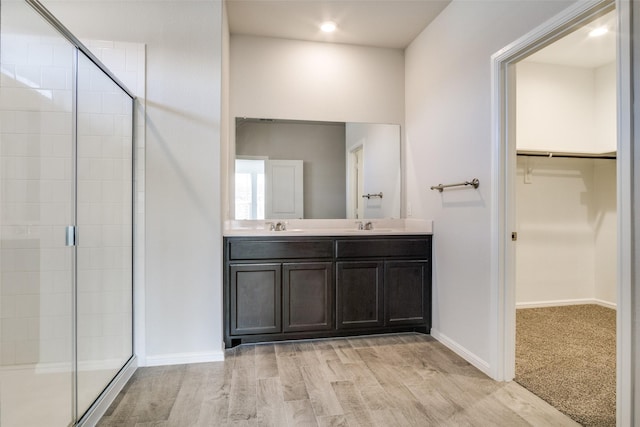 bathroom featuring hardwood / wood-style floors, vanity, and walk in shower