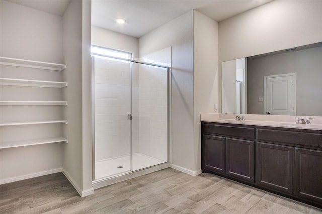 bathroom with vanity, wood-type flooring, and a shower with door