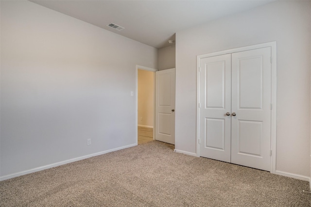 unfurnished bedroom featuring carpet floors and a closet