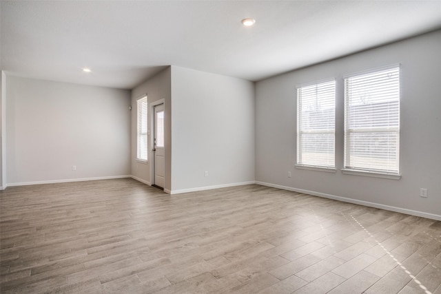 empty room featuring plenty of natural light and light hardwood / wood-style flooring