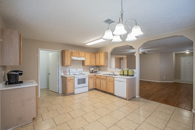 kitchen with ceiling fan with notable chandelier, white appliances, sink, light tile patterned floors, and decorative light fixtures