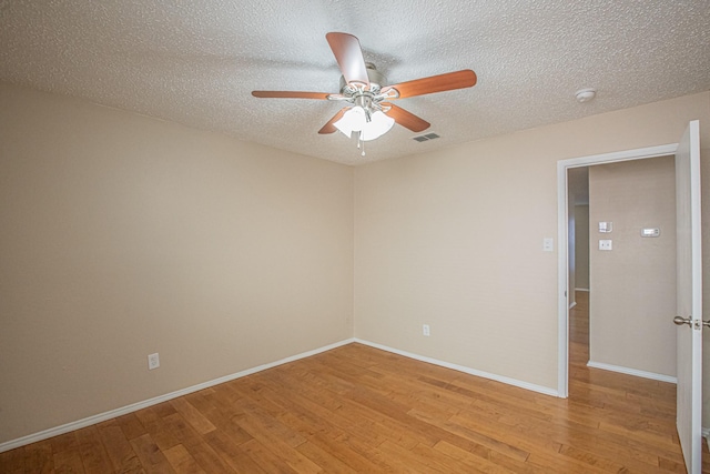 empty room featuring ceiling fan, a textured ceiling, and light hardwood / wood-style flooring