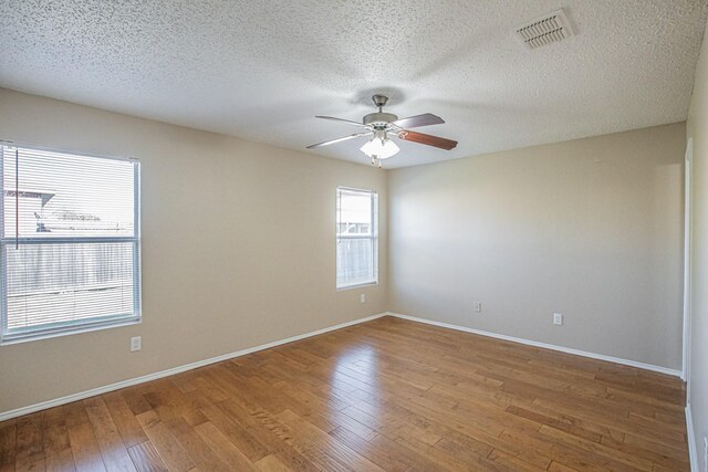 unfurnished room featuring ceiling fan, hardwood / wood-style floors, and a textured ceiling