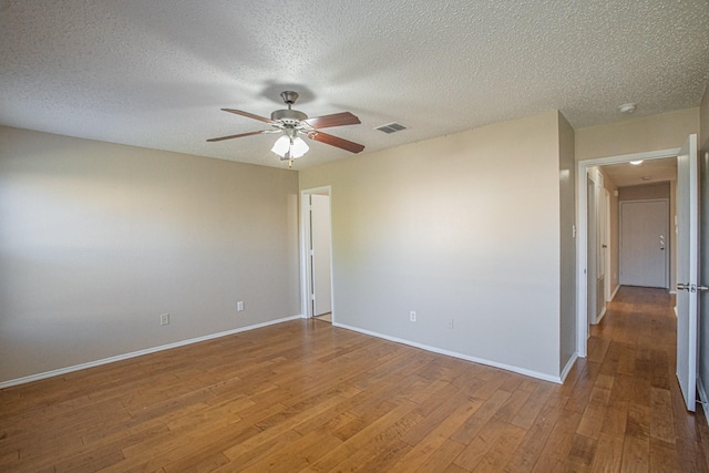 unfurnished room featuring ceiling fan, hardwood / wood-style floors, and a textured ceiling