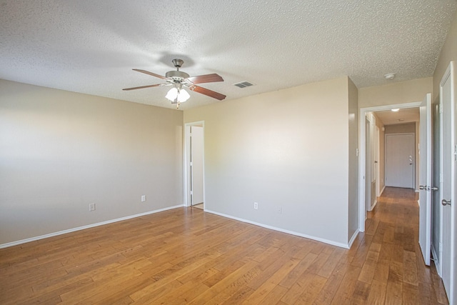 spare room featuring a textured ceiling, light hardwood / wood-style flooring, and ceiling fan