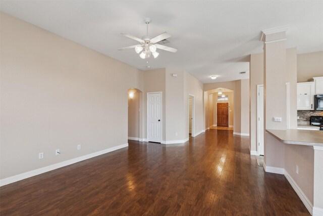 unfurnished living room with ceiling fan, plenty of natural light, lofted ceiling, and dark wood-type flooring