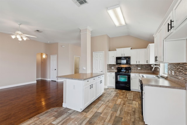 kitchen featuring black appliances, white cabinetry, a center island, and sink