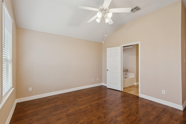 unfurnished bedroom with ceiling fan, multiple windows, dark hardwood / wood-style floors, and lofted ceiling