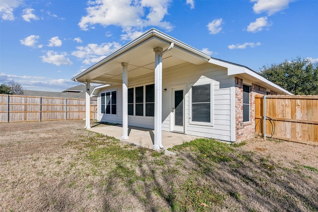 rear view of house featuring a patio area and a lawn