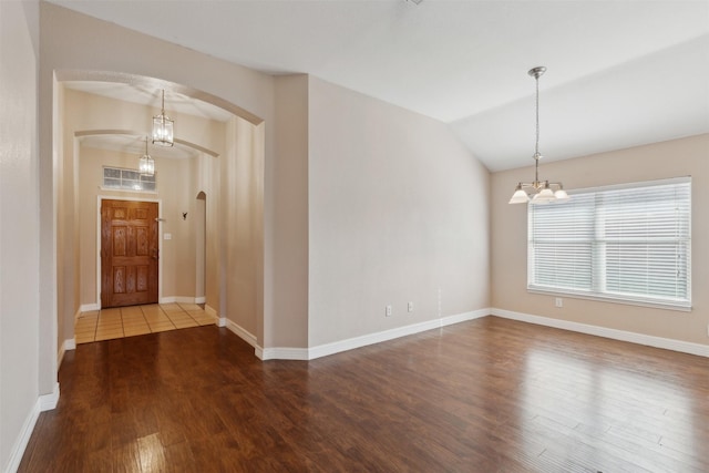 foyer featuring hardwood / wood-style flooring, a chandelier, and lofted ceiling