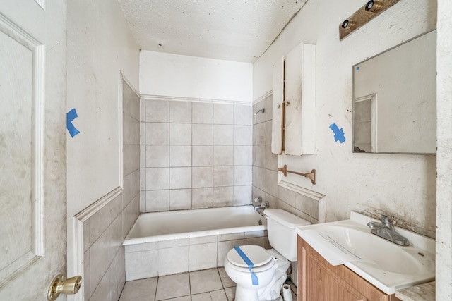 bathroom featuring vanity, tile patterned flooring, a relaxing tiled tub, toilet, and a textured ceiling