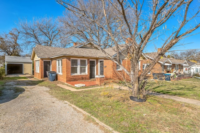 view of front of home featuring a garage, an outdoor structure, and a front yard