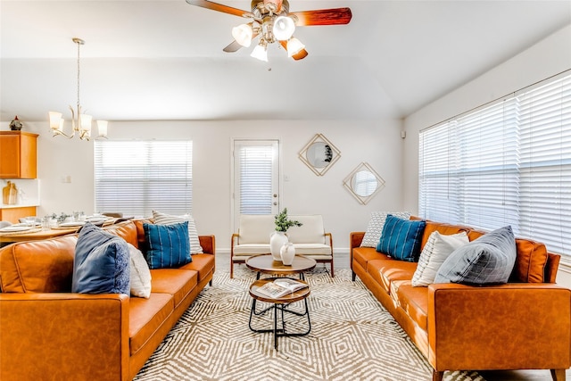 living room featuring ceiling fan with notable chandelier and lofted ceiling