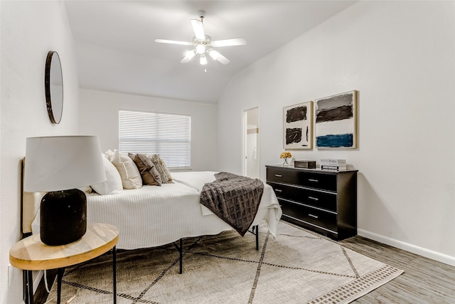 bedroom with ceiling fan, wood-type flooring, and lofted ceiling