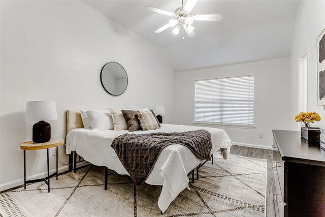 bedroom with ceiling fan, wood-type flooring, and vaulted ceiling