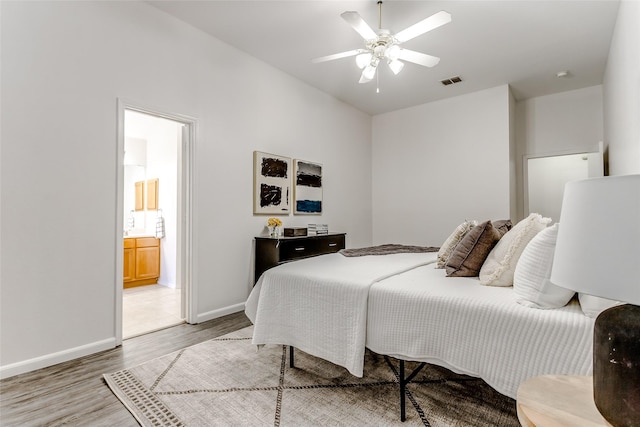 bedroom featuring ceiling fan, wood-type flooring, and ensuite bath