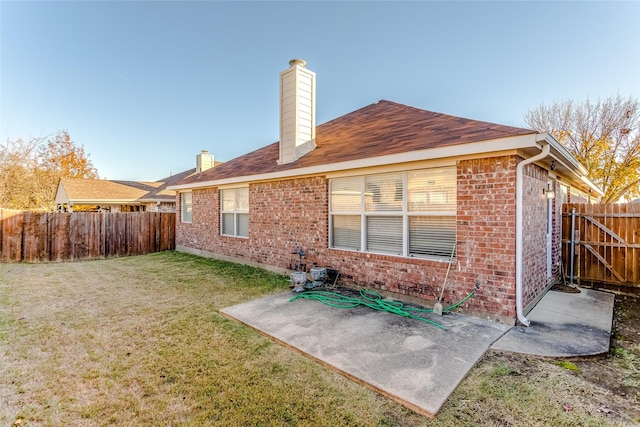 rear view of property with a yard and a patio