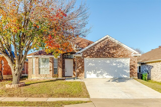 view of front of home with a front yard and a garage