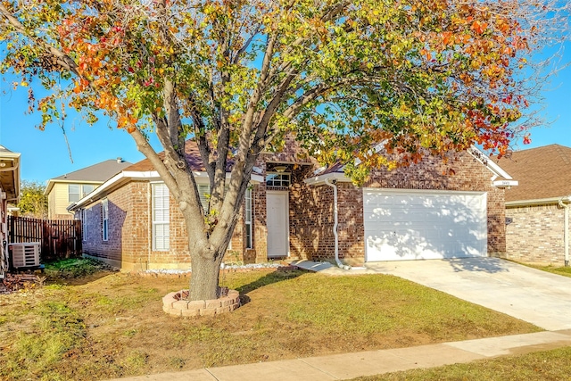 view of property hidden behind natural elements with central AC, a front yard, and a garage