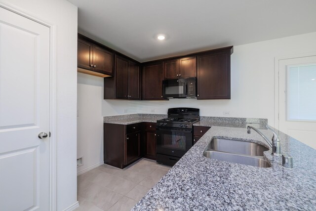 kitchen featuring light stone counters, dark brown cabinetry, sink, black appliances, and light tile patterned flooring