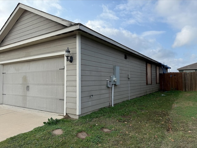 view of side of home featuring a garage and a lawn