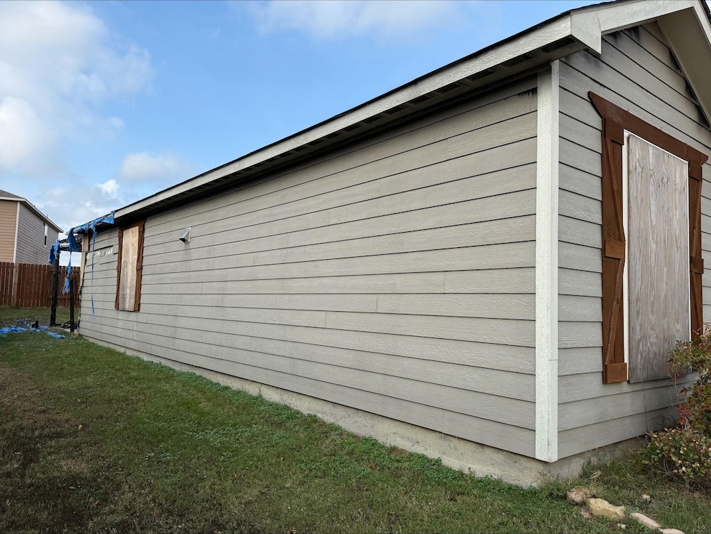 view of side of home with a yard