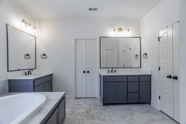 bathroom with tiled bath and vanity