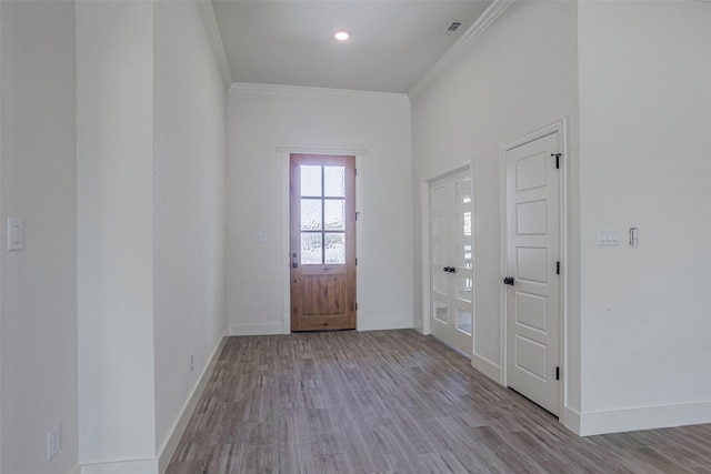 foyer entrance featuring light hardwood / wood-style floors and ornamental molding